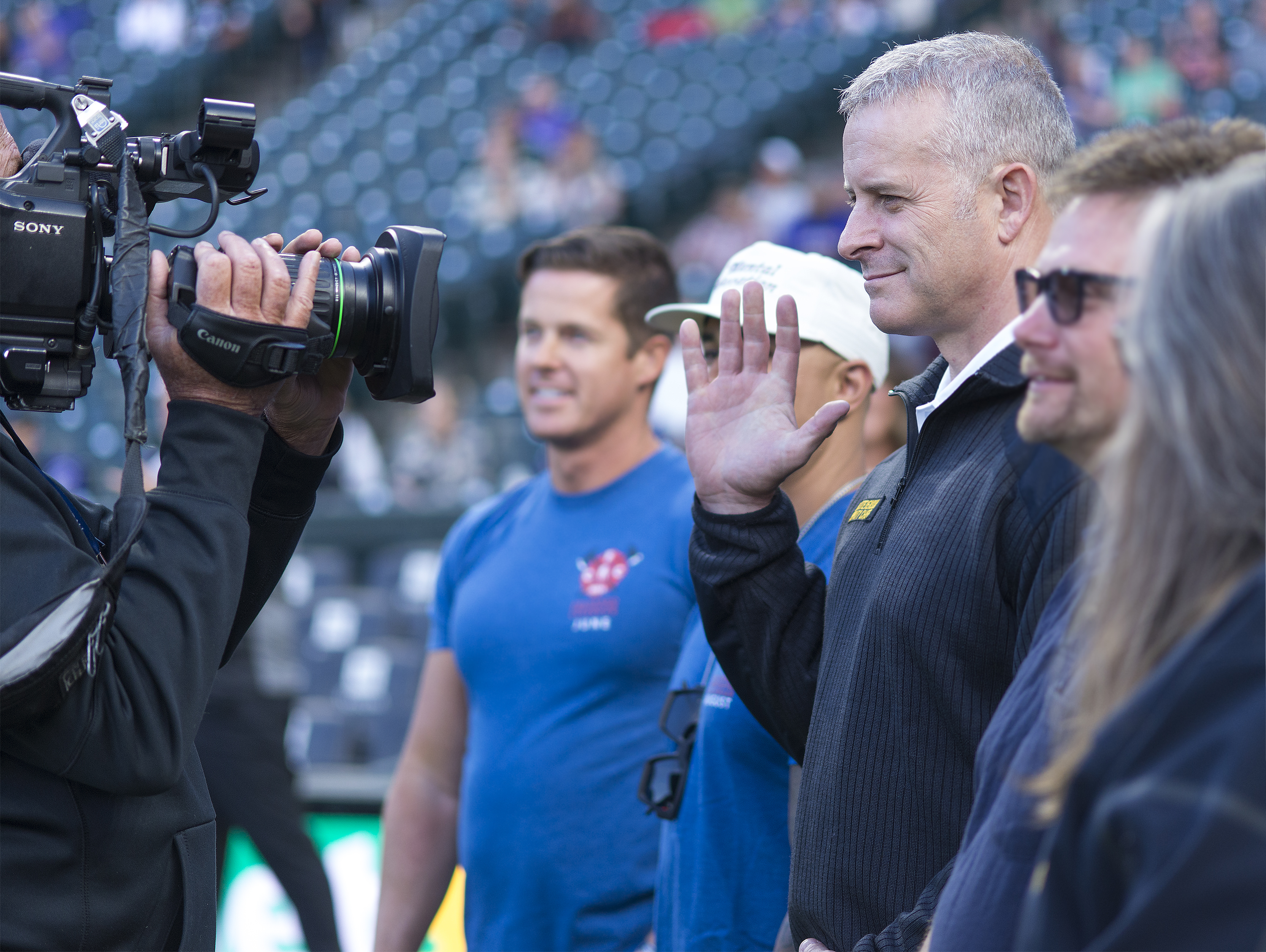 Denver Paramedic Division Deputy Chief Brent Stevenson waves to the crowd on the Coors field scoreboard.