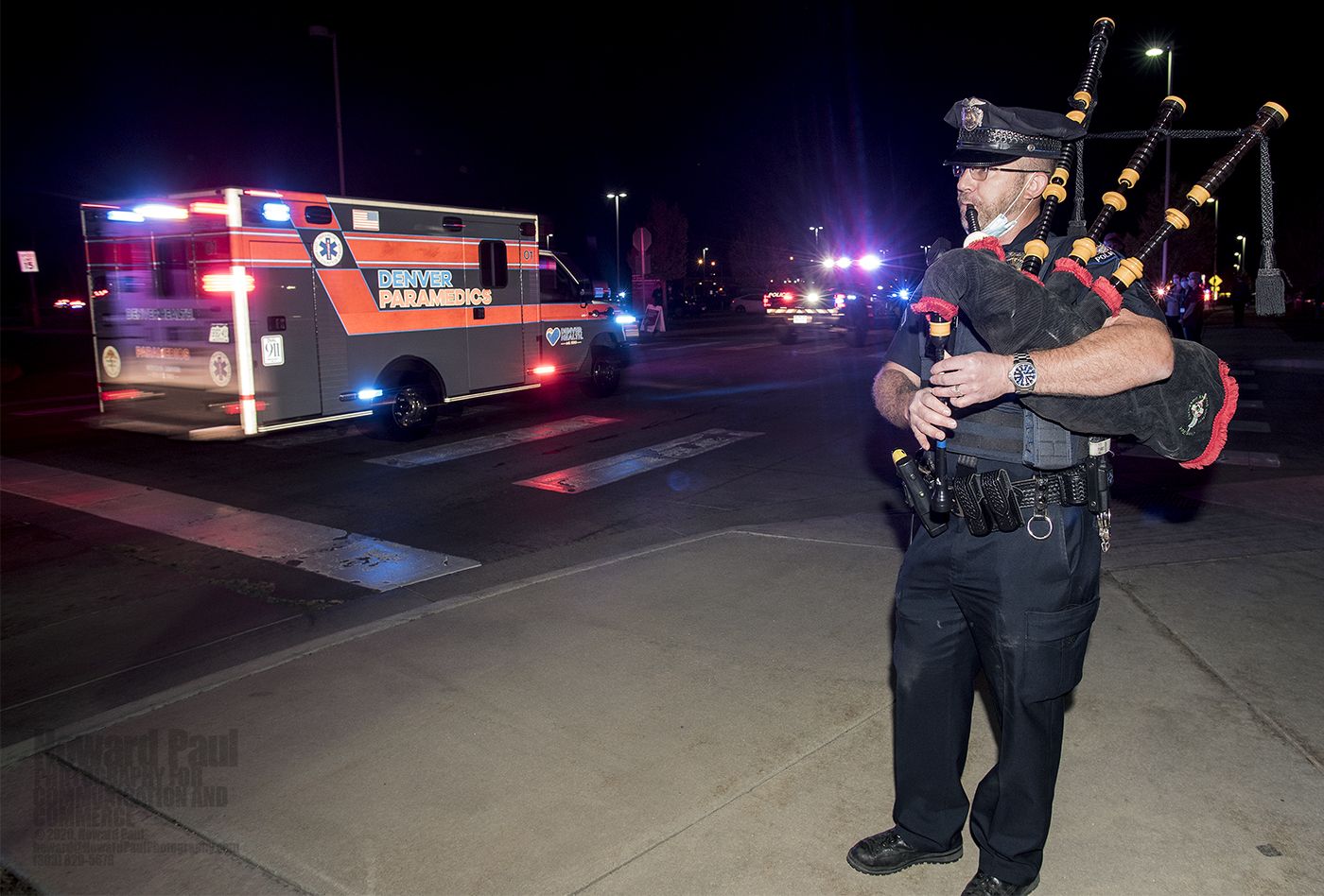 Aurora Police Department Officer David Cook plays the pipes as the procession passed University Hospital in Aurora.