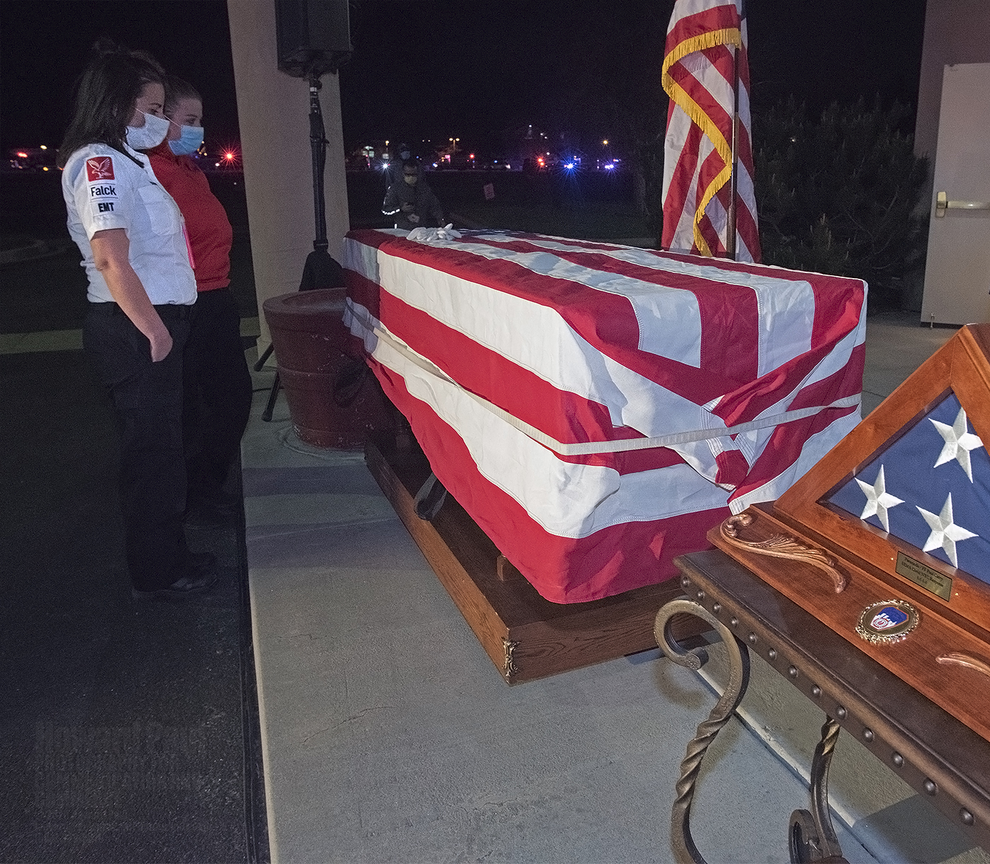 Falck-Colorado and Stadium Medical employees pay their last respects to Paul Cary. To the right is an American flag presented by the Fire Department of New York.